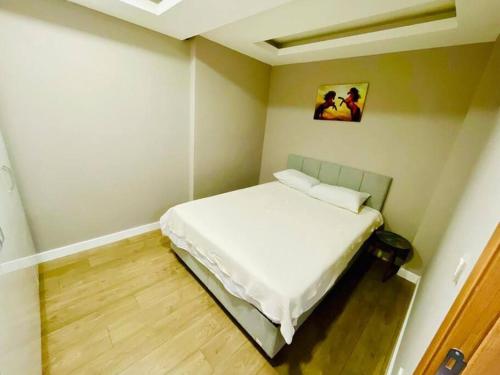 um pequeno quarto com uma cama branca em Atasuit12 em Istambul