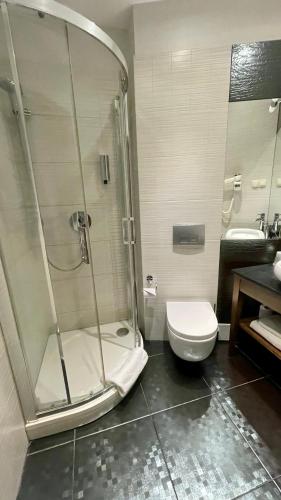 a bathroom with a shower and a toilet and a sink at Hotel Silvia Gold Gliwice in Gliwice