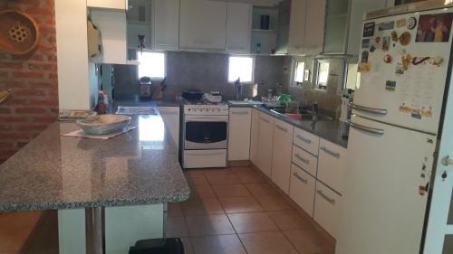 a kitchen with white appliances and a counter top at Casa de Campo LA CANTERA in Federación