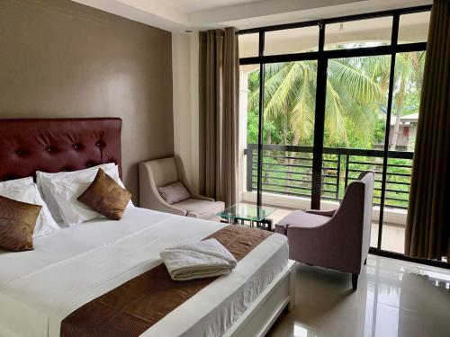 a bedroom with a bed and a large window at Adelaida Pensionne Hotel in Bantayan Island