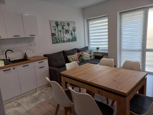 a kitchen and living room with a table and a couch at Apartament River Skierniewice in Skierniewice