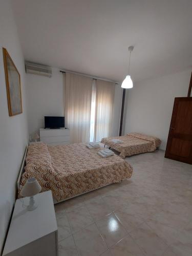 1 dormitorio con 2 camas y TV. en Domus Dejanas - Appartamento 180 mq a Quartu, en Quartu SantʼElena