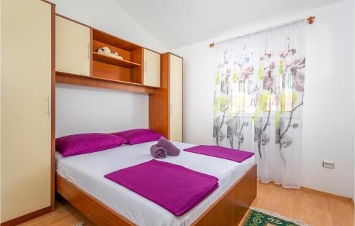 a bedroom with a large bed with purple pillows at Beautiful Apartment In Krk With Kitchen in Krk