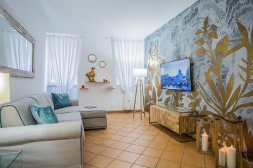 a living room with a couch and a tv on a wall at Domus Regola Luxury Apartment in Rome