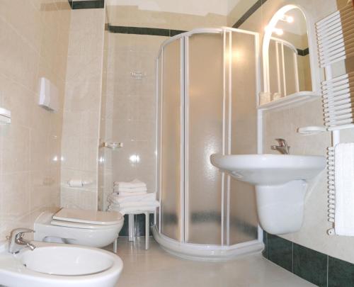 e bagno con doccia, servizi igienici e lavandino. di Albergo Casa Del Pellegrino a Monte SantʼAngelo