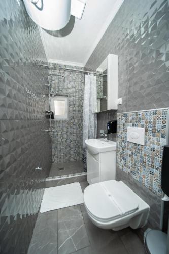 a bathroom with a toilet and a sink and a mirror at Darija Apartments - City Square in Ohrid