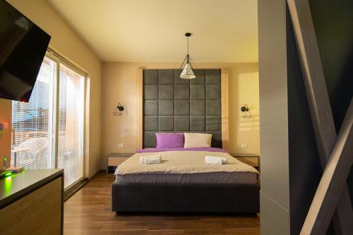 a bedroom with a large bed with purple pillows at Darija Apartments - City Square in Ohrid