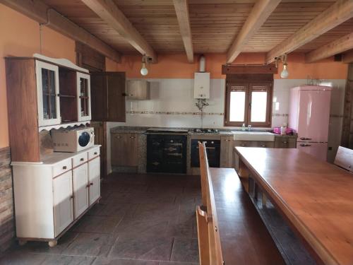 een keuken met een houten tafel en een koelkast bij Casa Antonio in Susañe del Sil