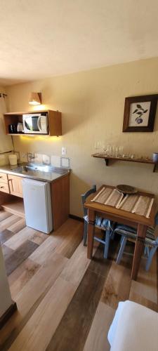 a kitchen with a table and a counter top at Pousada Capitão Cook in Praia do Rosa