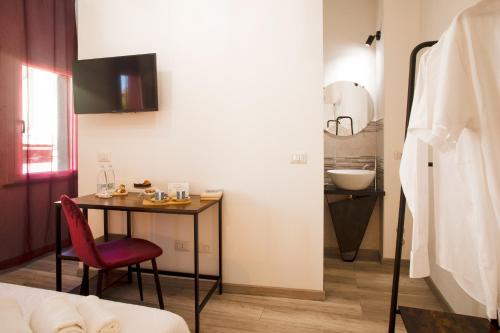 a room with a table and a chair and a sink at B&B da Baba in Ghizzano