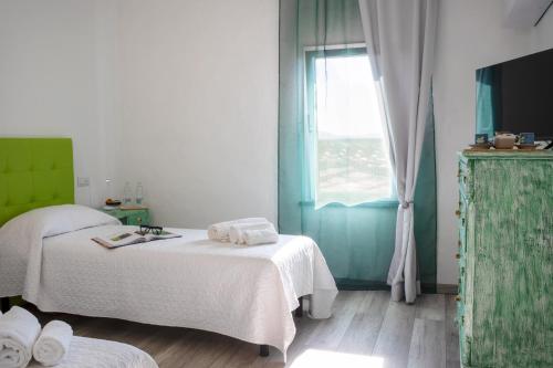 a bedroom with a white bed and a window at B&B da Baba in Ghizzano