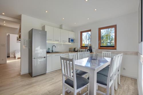 a kitchen and dining room with a table and chairs at Domki Na Wzgórzu Woda JACUZZI SAUNA ROWERY in Zawóz