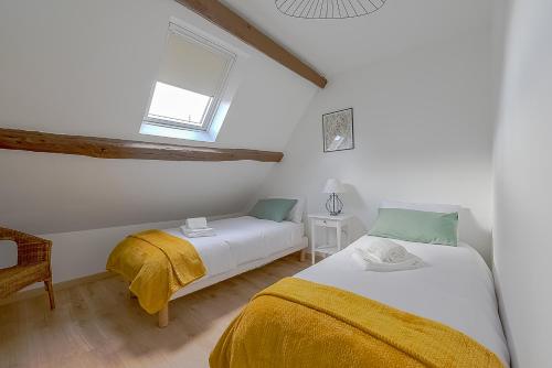 een slaapkamer met 2 bedden en een raam bij La Bodeguita : Roissy CDG, Parc Astérix, Parc Des Expositions in Marly-la-Ville