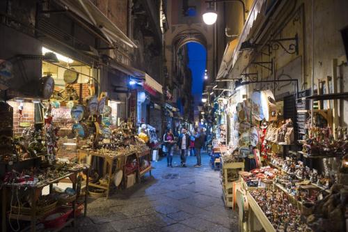 un grupo de personas caminando por un mercado en una calle en Neapolis Lifestyle, en Nápoles