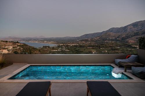 a swimming pool on a balcony with a view of the mountains at ZeusCave in Georgioupolis