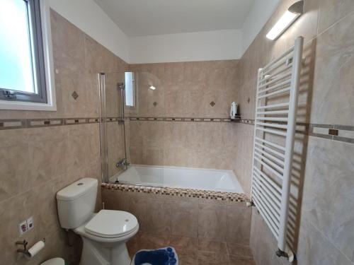 y baño con aseo y bañera. en Villa Victoria en Lárnaca