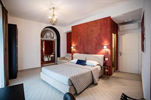 ein Schlafzimmer mit einem Bett und einer roten Wand in der Unterkunft LUDUS ROOMS in Rom