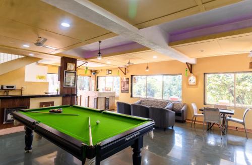 a living room with a pool table in a room at Saga Resort in Mahabaleshwar