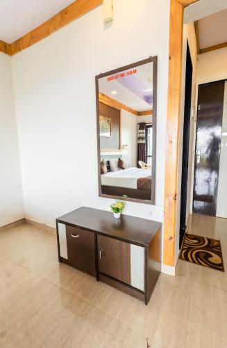 a room with a mirror and a table and a bed at Saga Resort in Mahabaleshwar