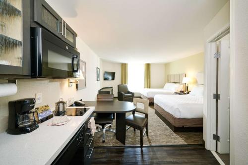 a hotel room with a kitchen and a bedroom at Sonesta Simply Suites Baltimore BWI Airport in Linthicum Heights