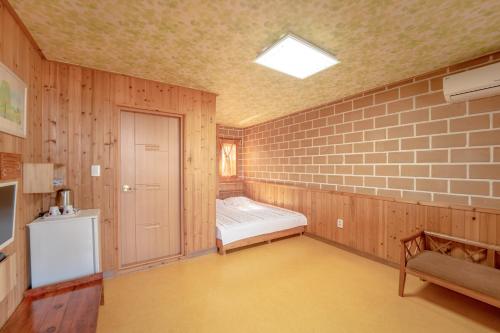 江陵市的住宿－葉松療養營地旅館，一间设有床铺和砖墙的房间