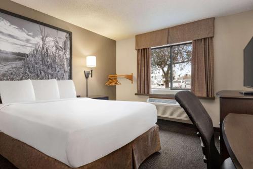 a hotel room with a large white bed and a window at Super 8 by Wyndham Lincoln North in Lincoln