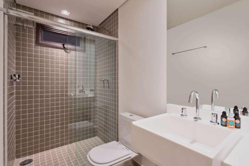 a bathroom with a sink and a toilet and a shower at Wyndham Ilhabela Casa Di Sirena in Ilhabela