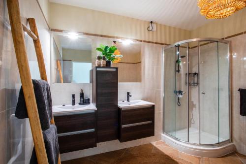 a bathroom with two sinks and a shower at Tropicana Palm Penthouse Jan Thiel, Willemstad Curacao in Jan Thiel