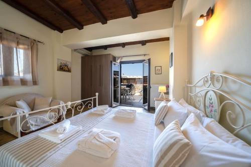 ein Schlafzimmer mit einem großen Bett mit weißer Bettwäsche in der Unterkunft Arhontariki Luxury Apartment in Panormos