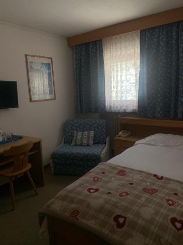 een hotelkamer met een bed en een stoel bij Hotel Cime Bianche in Breuil-Cervinia