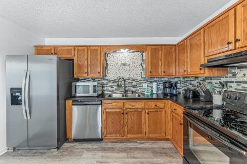 a kitchen with wooden cabinets and a stainless steel refrigerator at Pirate's Hideaway in Gulf Shores