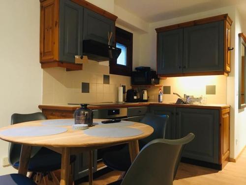 a kitchen with a wooden table and chairs in it at Mountain Apartment Gerlitzen in Kanzelhöhe