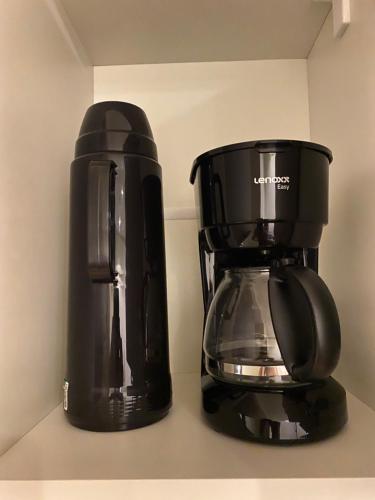a coffee maker and a coffee pot sitting on a counter at Flat Apart America Campos in Campos dos Goytacazes