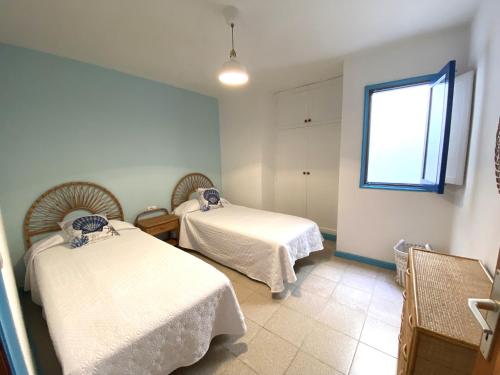 Habitación hospitalaria con 2 camas y ventana en APARTAMENTO AZUL, en Orzola