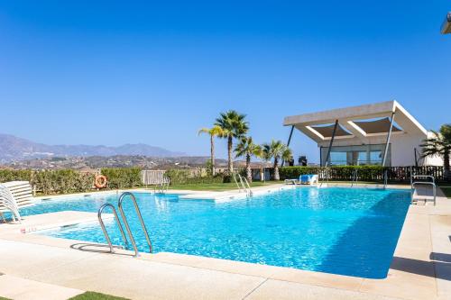 basen z błękitną wodą i palmami w obiekcie Penthouse Lord of Mijas , Sea View 6P, Casa Banderas, D23A w mieście La Cala de Mijas