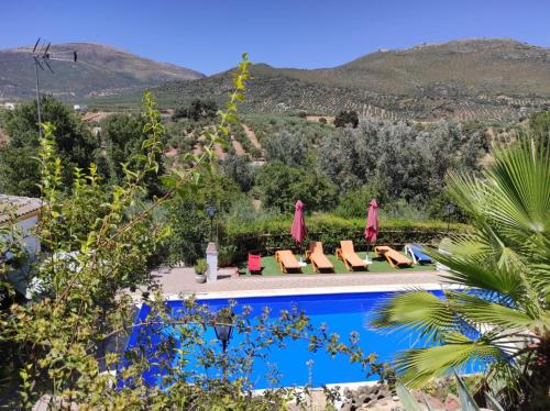 a villa with a pool and mountains in the background at Puente Piedra in Carcabuey