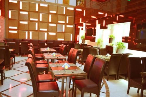 a dining room with wooden tables and chairs at Dorus Hotel in Dubai