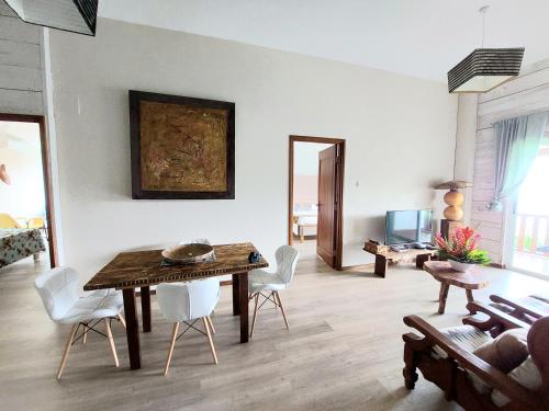 My Paradise في باي لازار ماهي: غرفة معيشة مع طاولة خشبية وكراسي بيضاء