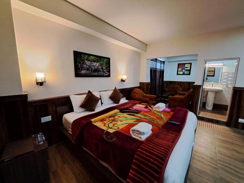 a bedroom with a large bed and a living room at Hotel Golden Sunrise & Spa in Pelling