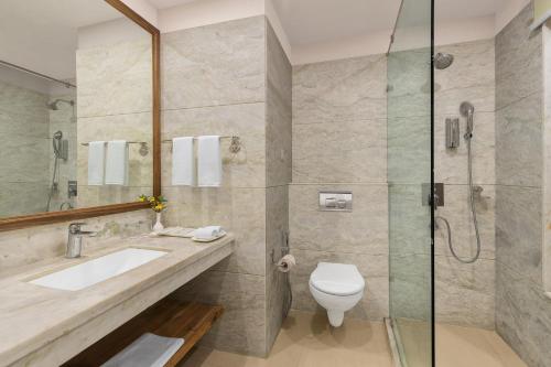 a bathroom with a toilet and a sink and a shower at Fortune Park Kufri, Shimla - Member ITC's Hotel Group in Shimla