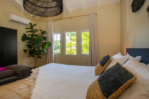 Jan Thiel的住宿－Tropicana Palm Penthouse Jan Thiel, Willemstad Curacao，卧室设有一张白色大床和一扇窗户。