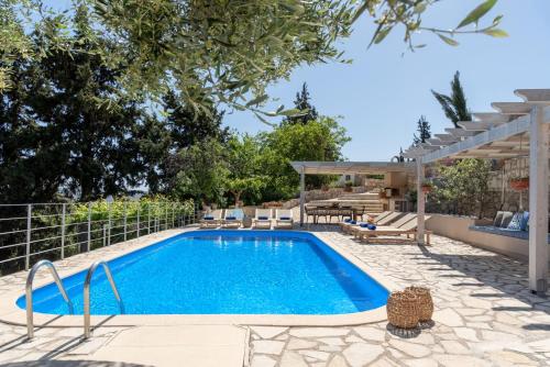 una piscina en un patio con una casa en Villa Chrysallis with heated pool, en Georgioupolis