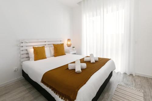 a bedroom with a large bed with two towels on it at Swell House in Ferrel