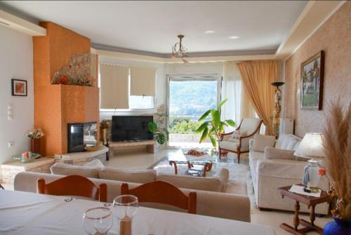 a living room filled with furniture and a large window at Kosmira Big House in Ioannina