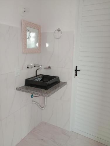 Baño blanco con lavabo negro y espejo en Recanto das Videiras, en Maria da Fé