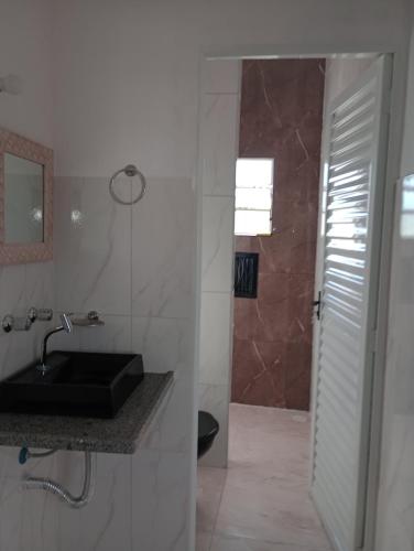 a bathroom with a black sink and a shower at Recanto das Videiras in Maria da Fé