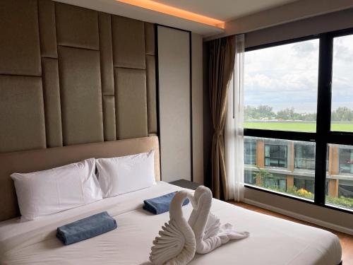 un dormitorio con una cama con una decoración de cisne en Panora Deluxe sea view apartment by Lofty en Surin Beach
