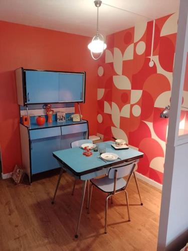- une cuisine avec une table et une télévision dans la chambre dans l'établissement The Seventies Appart rétro (proche gare et centre ville), à Amiens