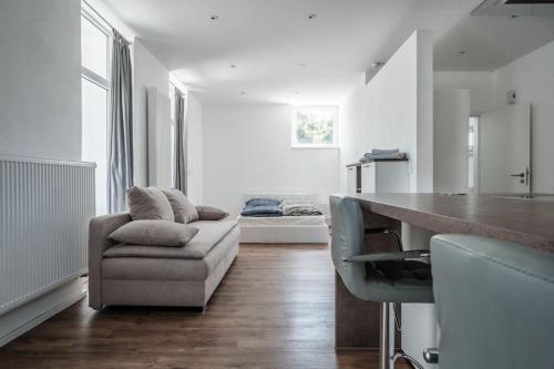 a living room with a couch and a table at Loft mit großer Terrasse bei der Kinderklinik 2C in Siegen