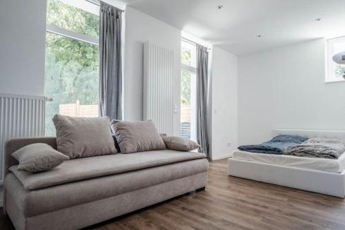 uma sala de estar com um sofá e uma cama em Loft mit großer Terrasse bei der Kinderklinik 2C em Siegen